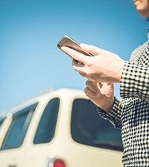 車の引取の連絡を待つ男性